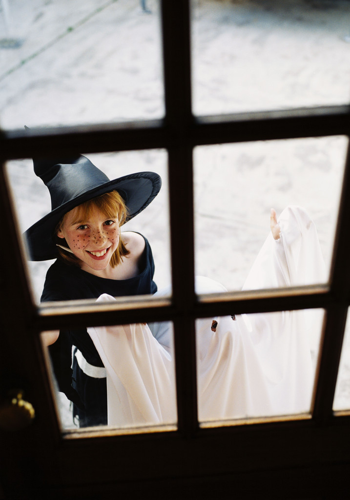 View Through a Window of a Girl (8-10) Dressed As a Witch for Trick Or Treat